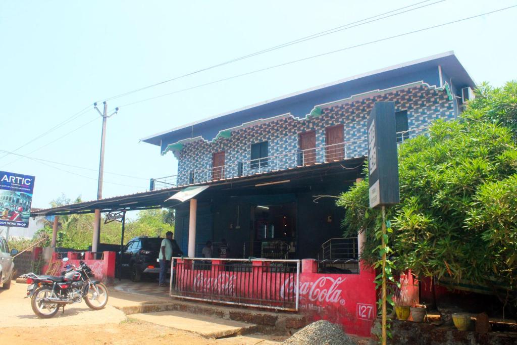 a building with a motorcycle parked in front of it at Harsh Guest House in Cola