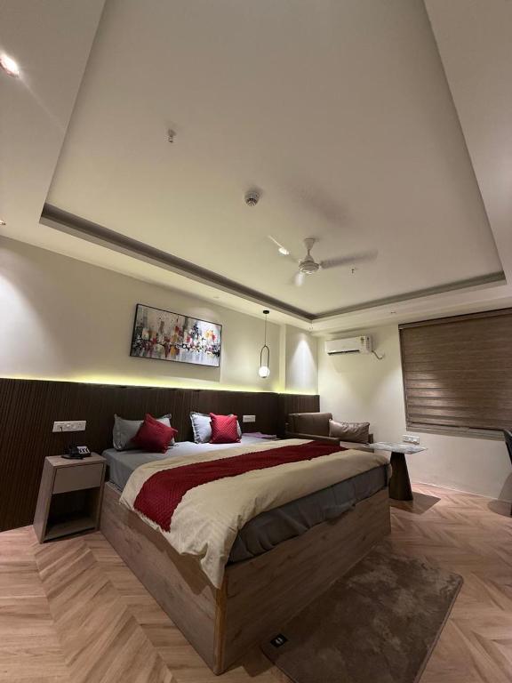 a large bedroom with a large bed with red pillows at LaCasa Heights in Greater Noida