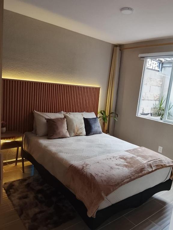 a bedroom with a large bed with a window at Depto Moderno Cerca de AIFA estacionamiento wifi in Santa Cruz Tecamac