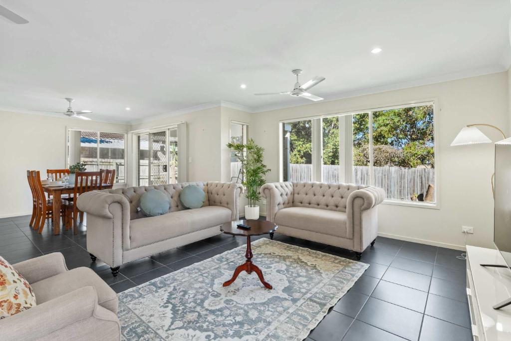 a living room with two couches and a table at Comfortable 4BR Coomer Escape Close to Everything in Gold Coast