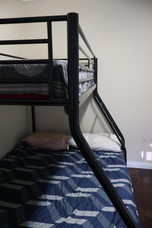 a black bunk bed with a blue and white comforter at Normalee manor hostel in Deanmill