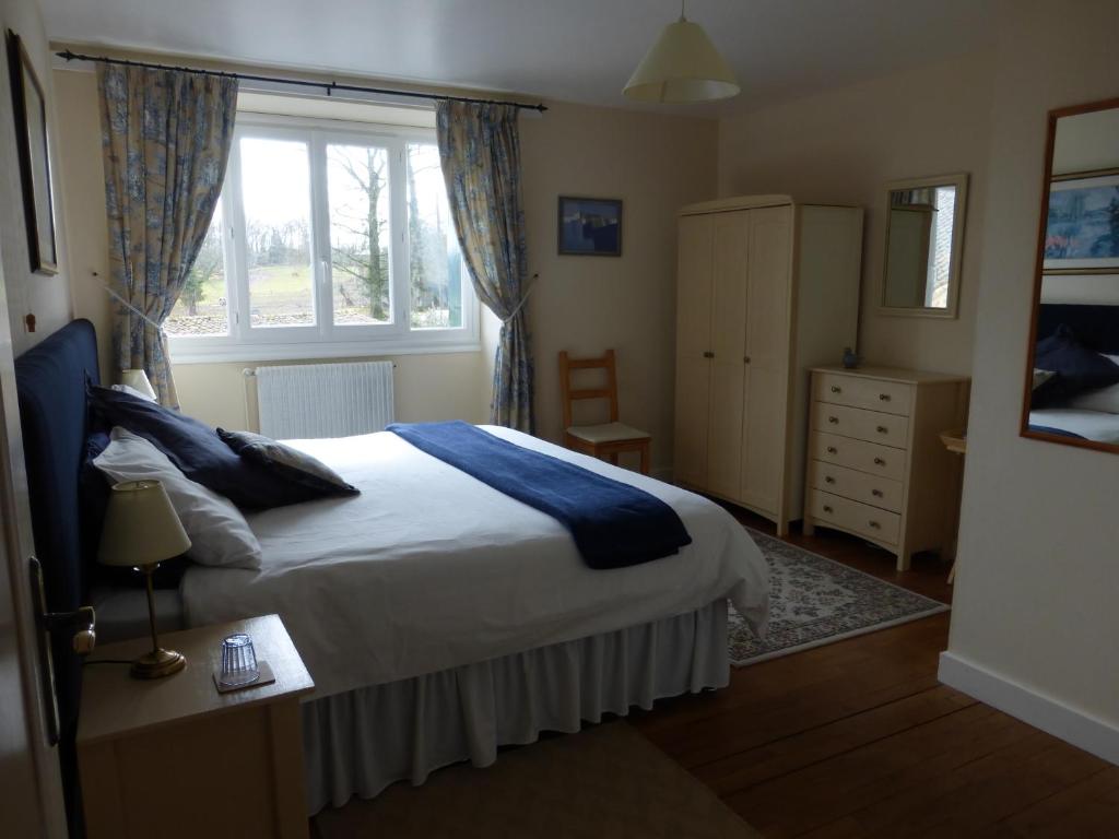 a bedroom with a bed and a window at L'Hirondelle Chambres d'Hotes in Saint-Mathieu