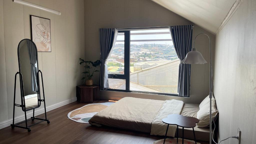 a bedroom with a bed and a large window at Nhà bạn Nhí in Khu Chi Lăng