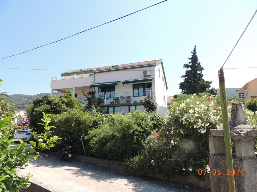 ein Gebäude mit vielen Pflanzen davor in der Unterkunft Apartments Suljic in Stari Grad