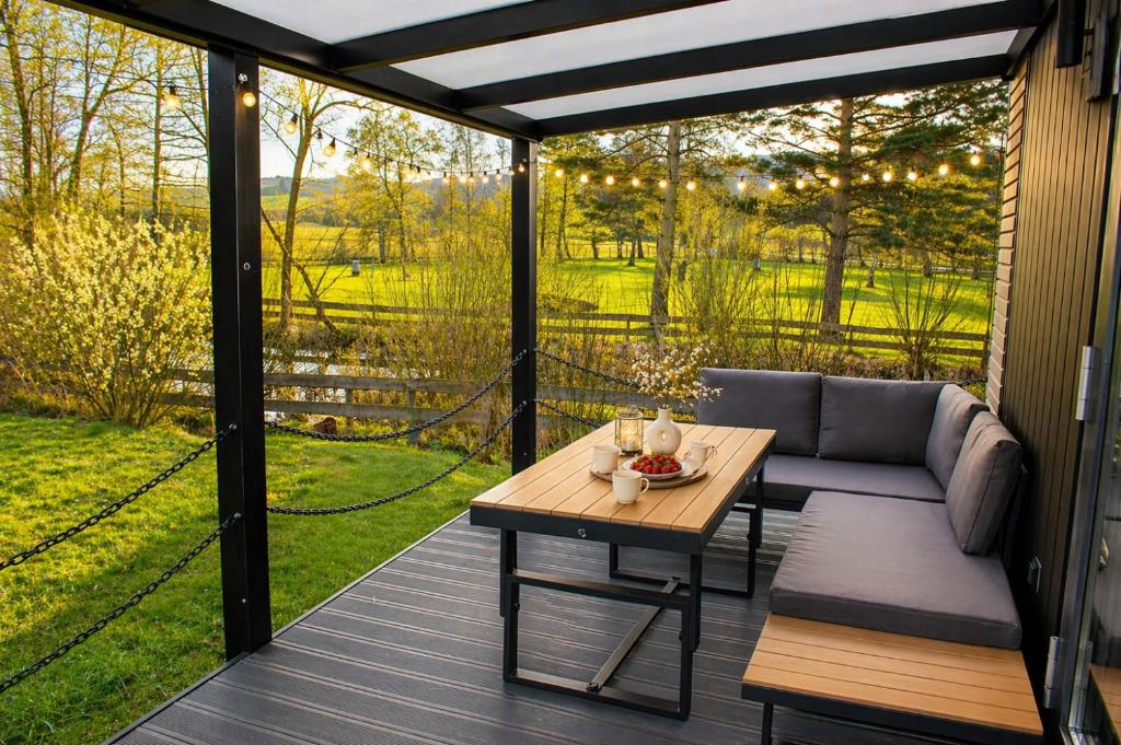 a screened in porch with a couch and a table at Romantisches Tiny House direkt am See, Ruhe & Natur in Salzhemmendorf