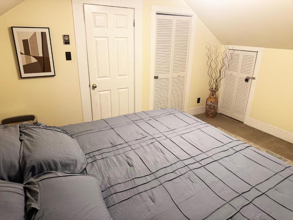a bedroom with a bed with a blue blanket at Cute as HECK! in Tacoma