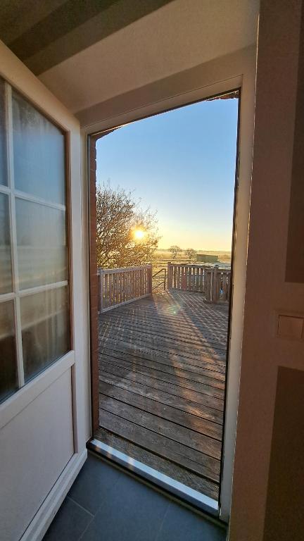 a sliding glass door with a view of a deck at Nordmannsland I in Sudermarsch
