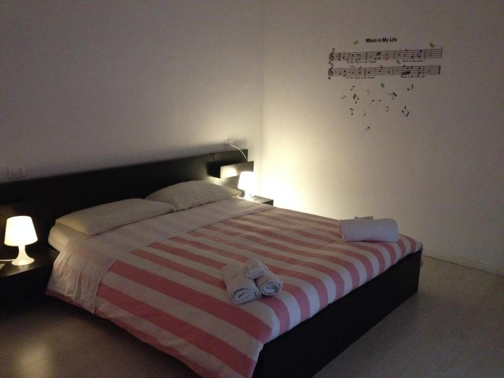 a bedroom with a striped bed with towels on it at Il Guasco Rooms in Ancona