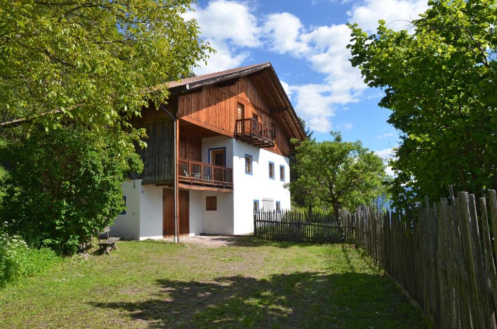 a house with a wooden fence in front of it at Kohlstatt Hof Ferienhaus in Verano