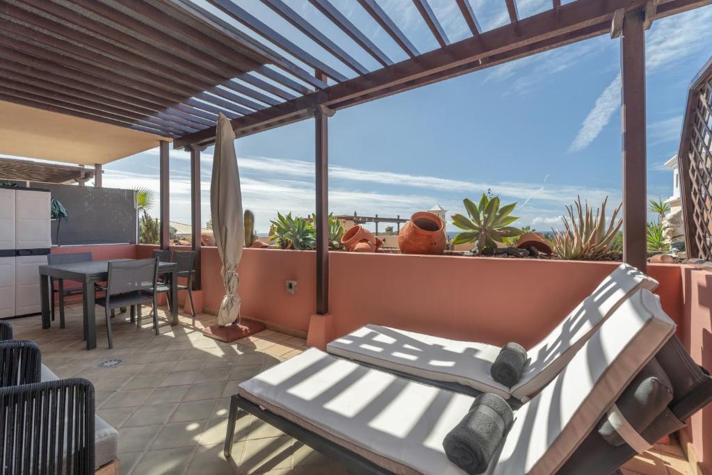 a patio with a bench and a table on a balcony at Apartamento Duque Beach in Adeje