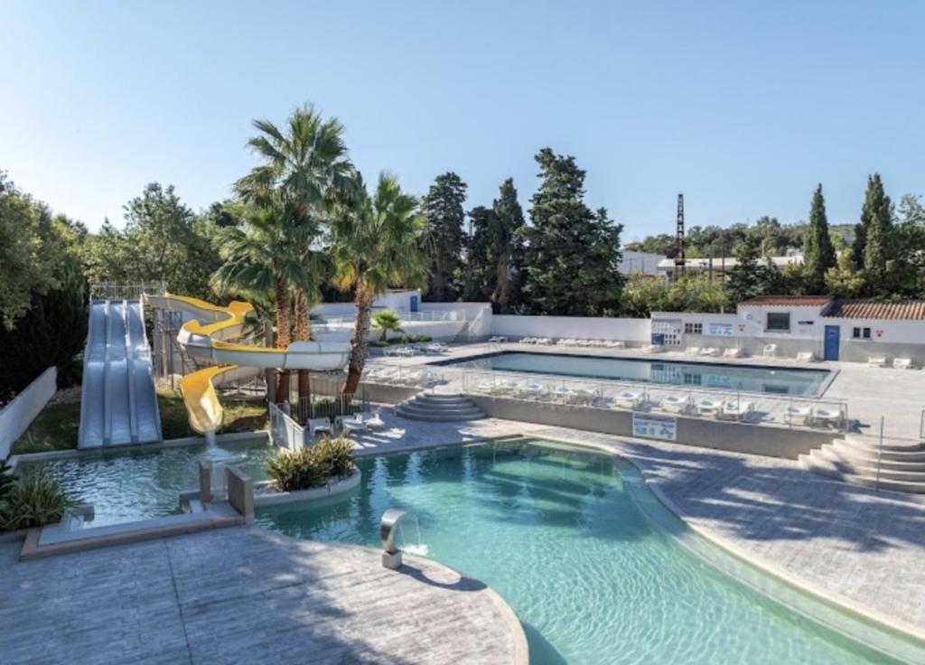 a pool at a resort with a water slide at Mobil home 3 chambres - Homair parc des 7 fonts 3 étoiles in Agde