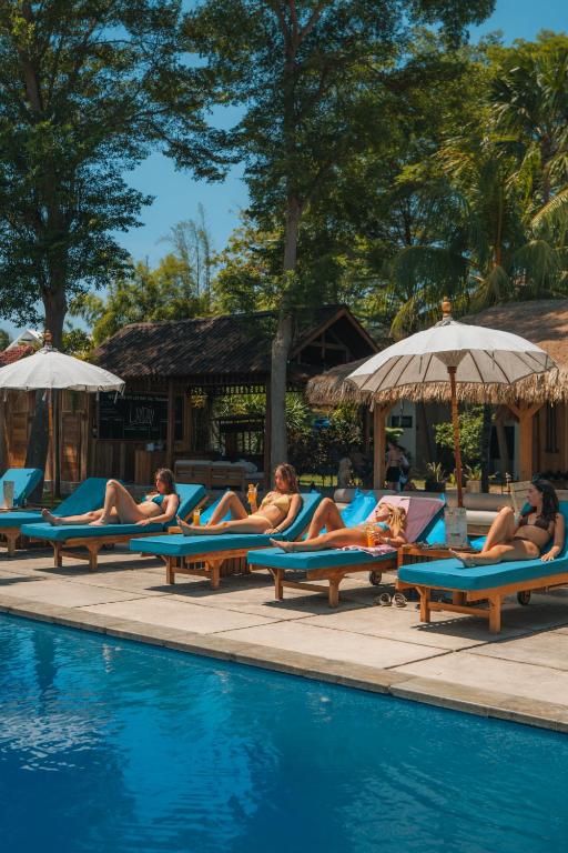 a group of people laying on lounge chairs by a pool at Lay Day Gili T in Gili Trawangan