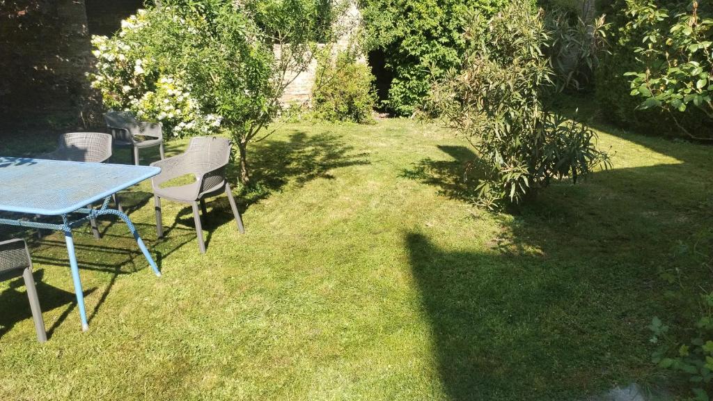 a table and chairs sitting in the grass at Sweet garden in La Fère