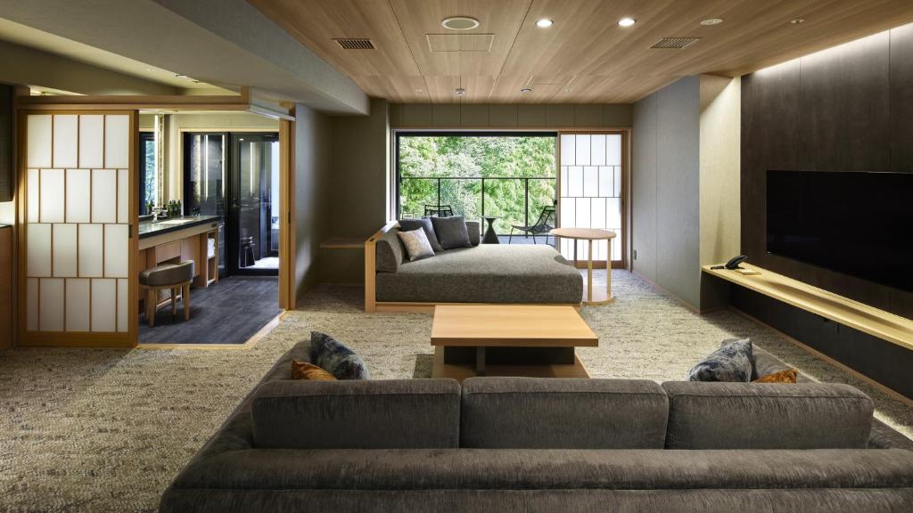 a living room with a couch and a tv at Hatsuhana in Hakone