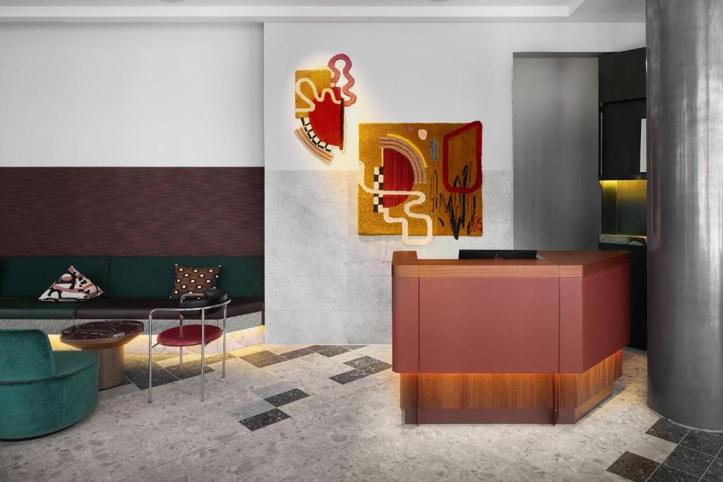a lobby with a reception desk and a couch at Kimpton Main Frankfurt by IHG in Frankfurt