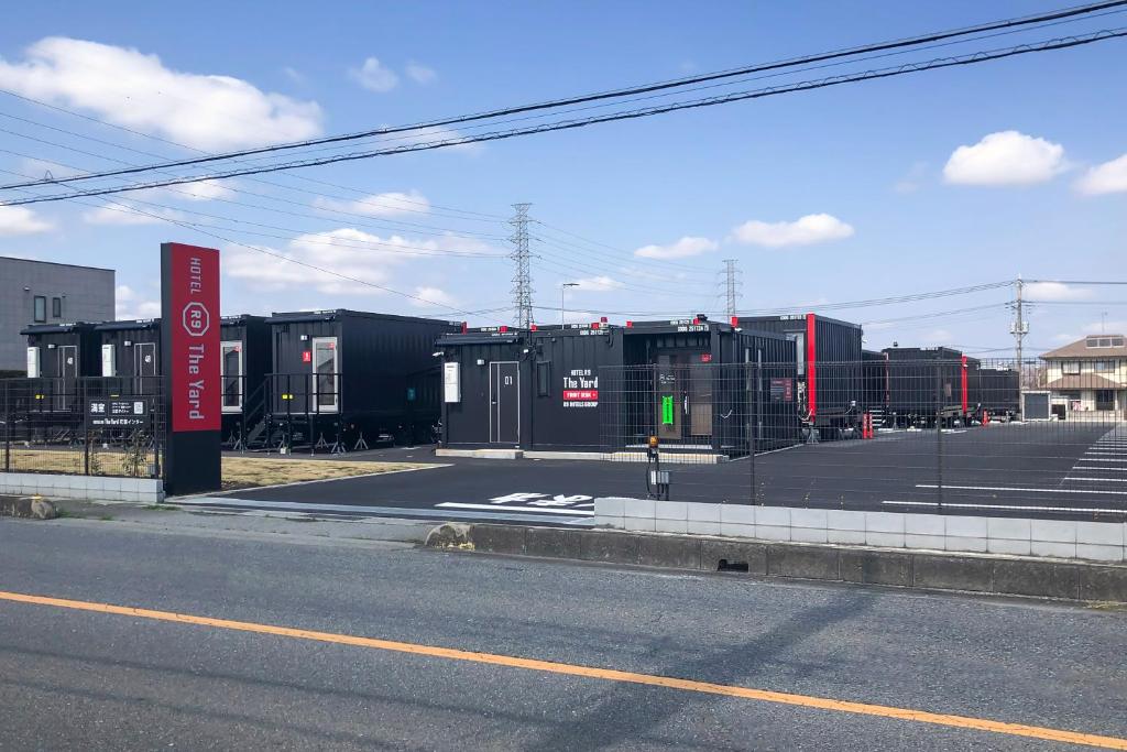 an empty parking lot with a bunch of shipping containers at HOTEL R9 The Yard Hanazonointer in Imaichi