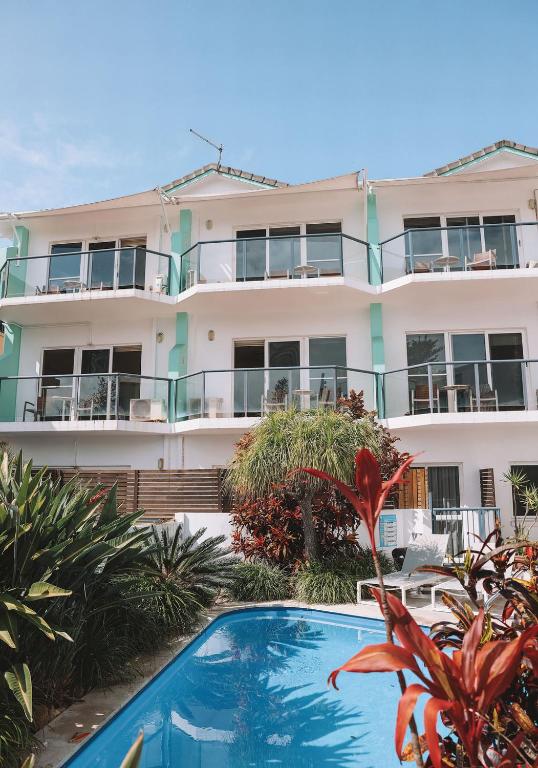 an apartment building with a swimming pool in front of it at Yamba Beach Motel in Yamba
