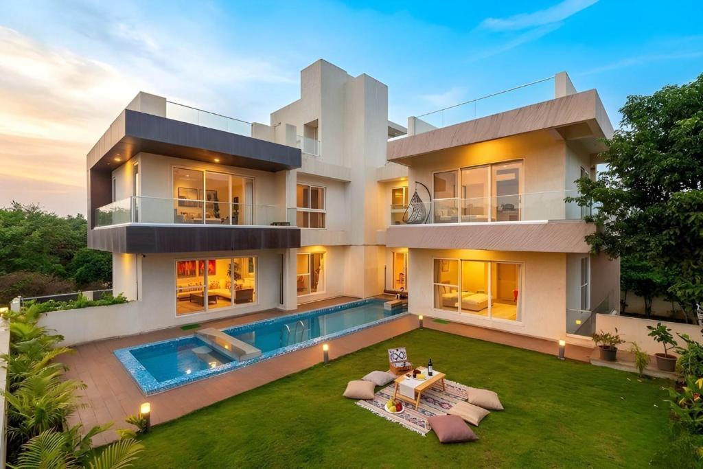 a large white house with a swimming pool at Villa Azul by StayVista, offering A snooker table, Terrace, Swimming pool & A spacious lawn with a charming gazebo for a perfect getaway in Lonavala