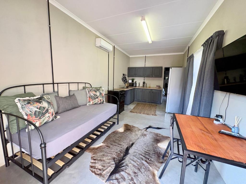 a living room with a couch and a table at Stylish One Bedroom Garden Suite in Polokwane