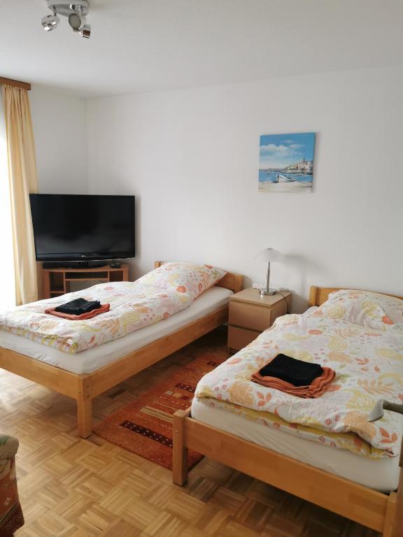 a room with two beds and a flat screen tv at Schöne Ferienwohnung Wetzlar in Wetzlar