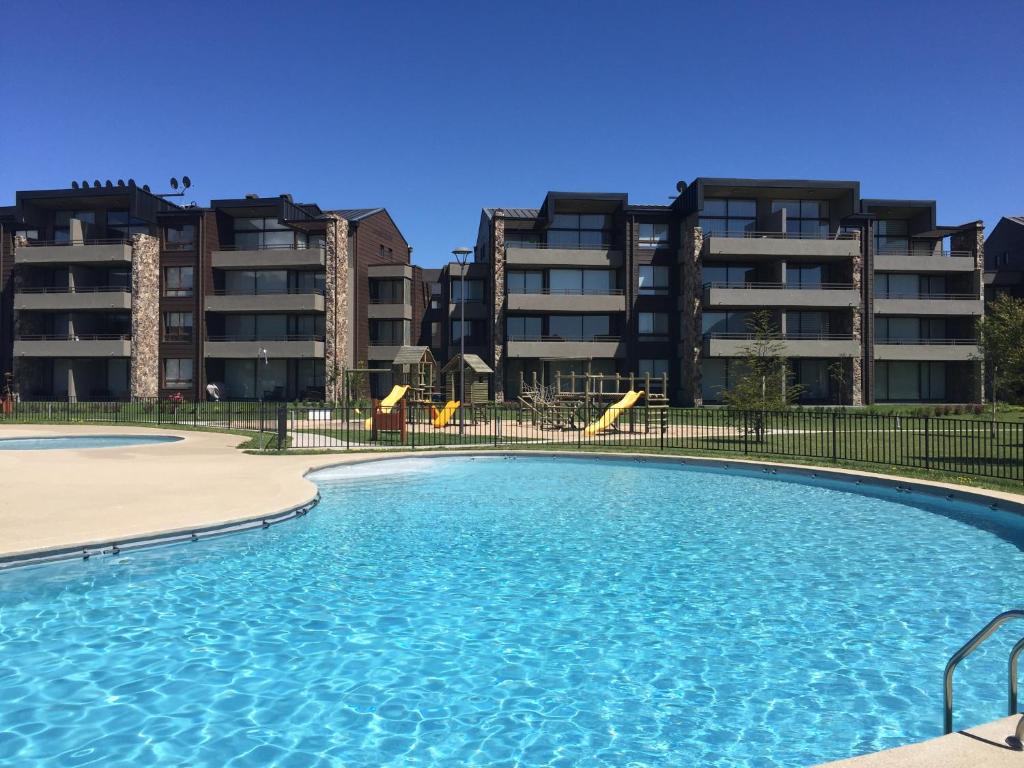 una piscina frente a algunos edificios de apartamentos en Departamento Costa Pucón 403, en Pucón