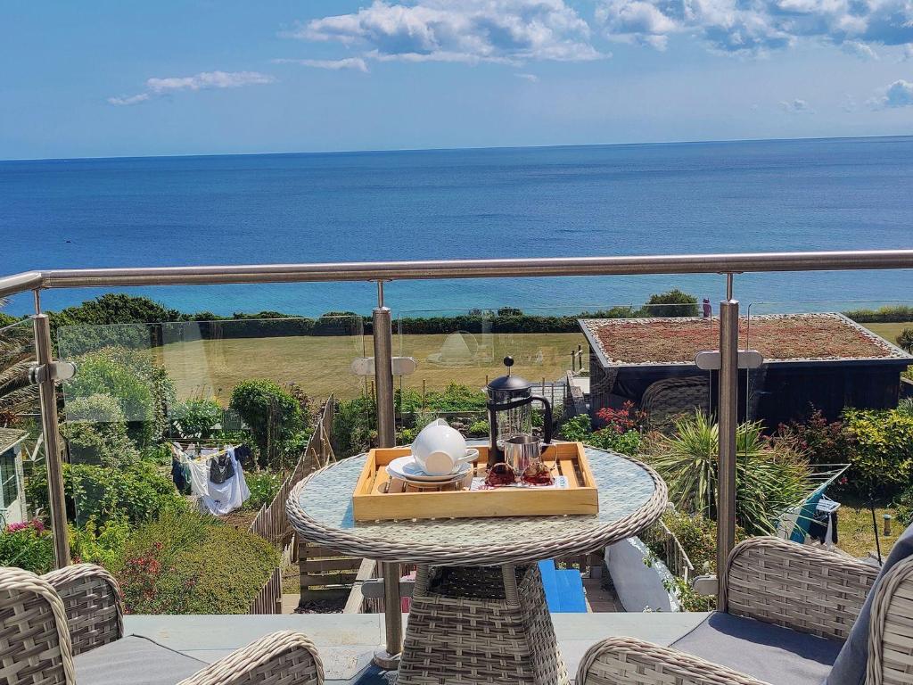 a table on a balcony with a view of the ocean at Ty Bryn in Marazion