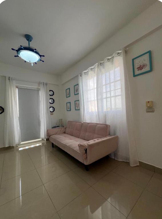 a living room with a couch and a window at A pasos de la playa y el centro de Bayahibe in Bayahibe