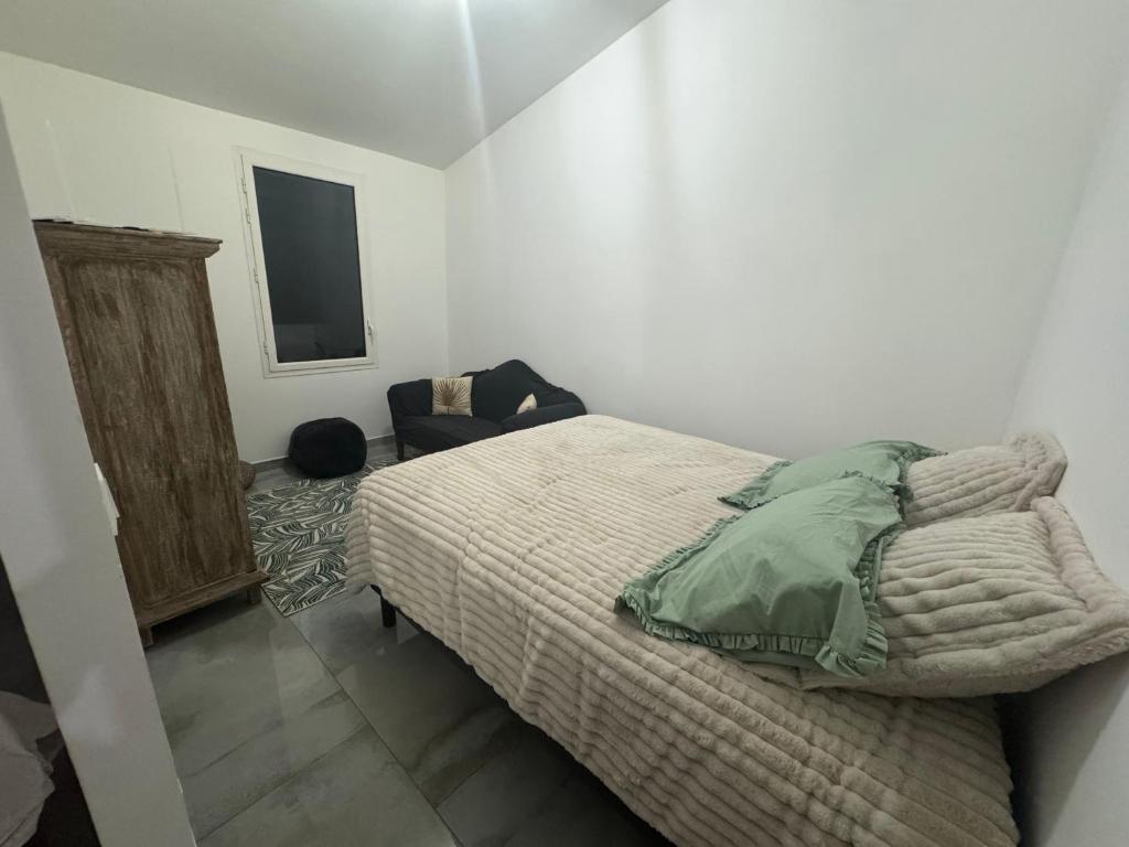 a bedroom with a bed and a chair in it at Arche du cap de bonne esperance in Sainte-Rose