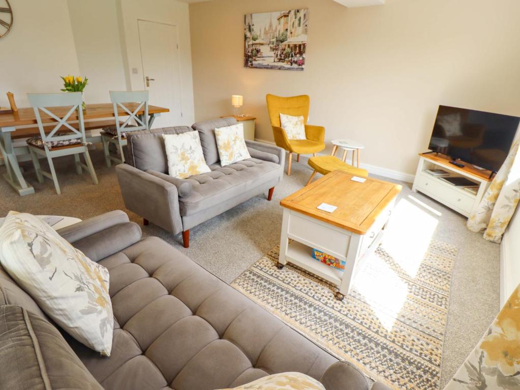 a living room with a couch and a table at Field View in North Walsham