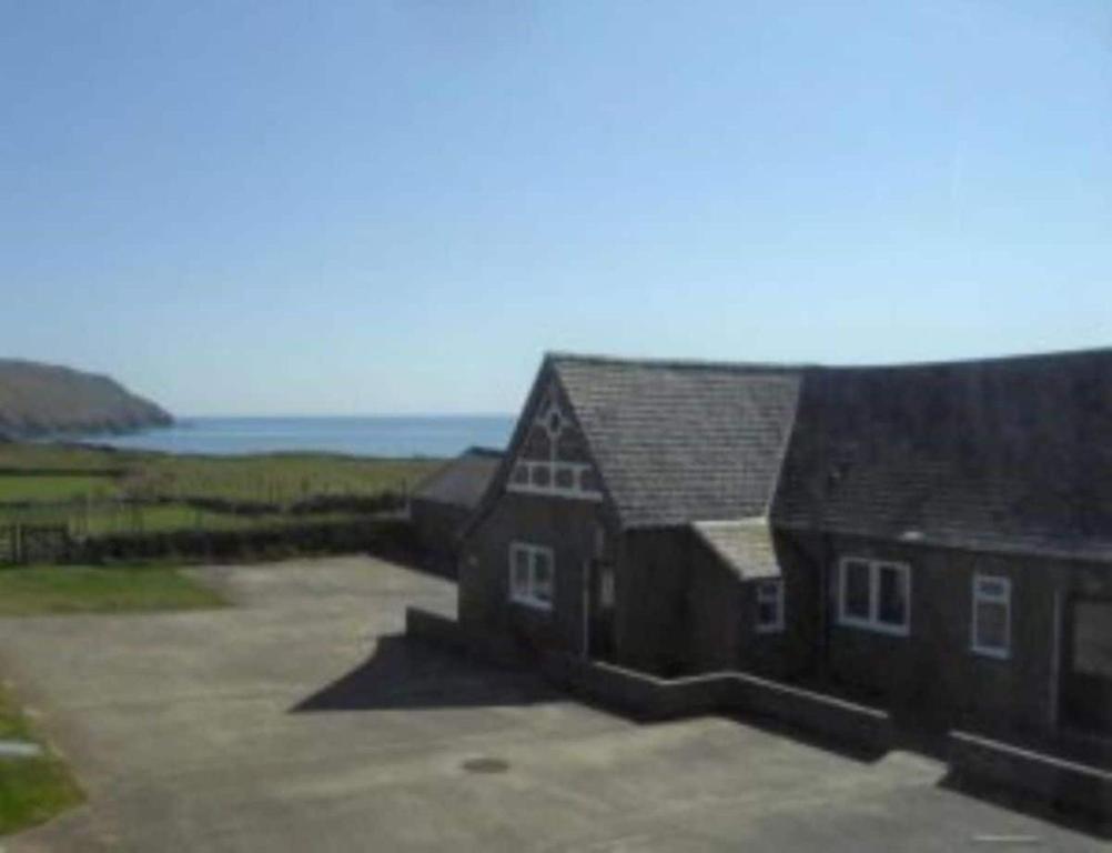 a large house with a large parking lot next to the ocean at Cilan in Llangian