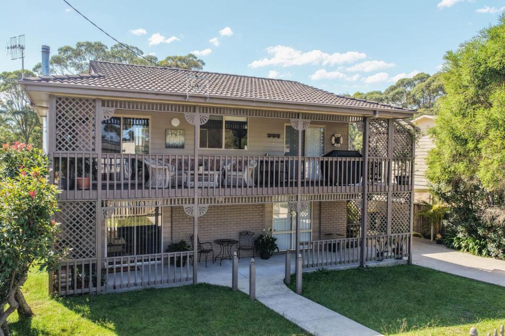 a house with a deck with chairs on it at Seabreeze Cottage in Manyana