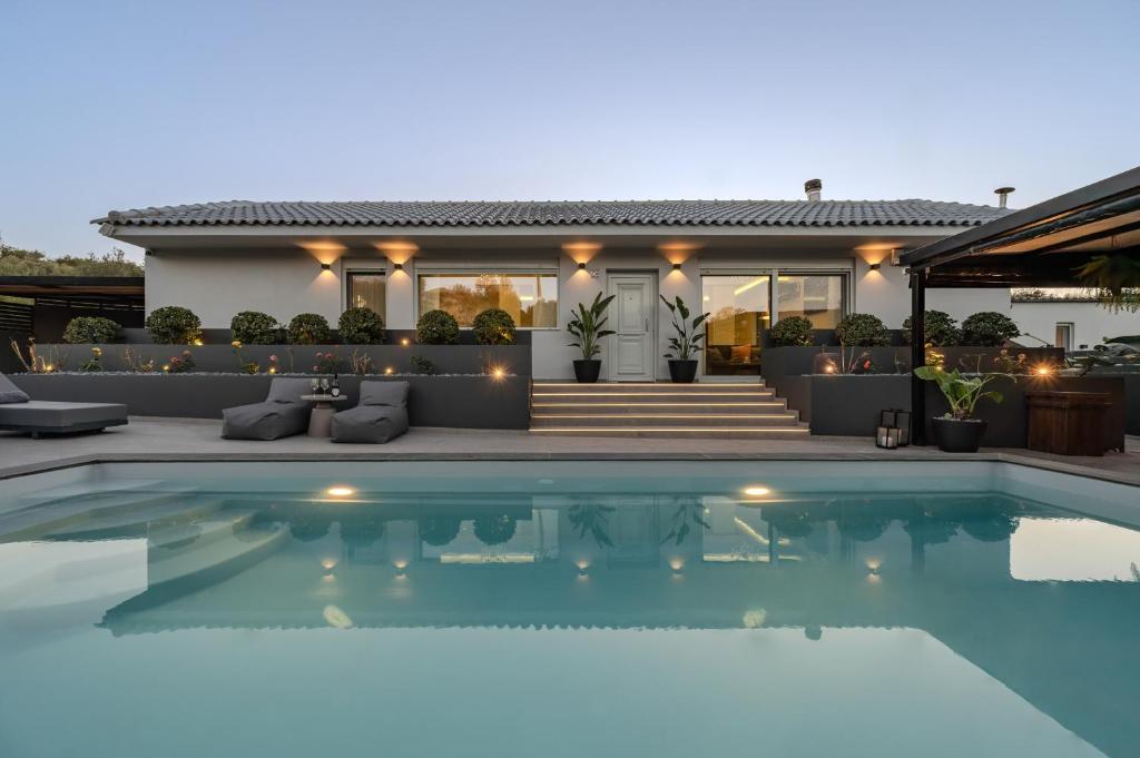 a house with a swimming pool in front of a house at Solena Villa in Stavromenos
