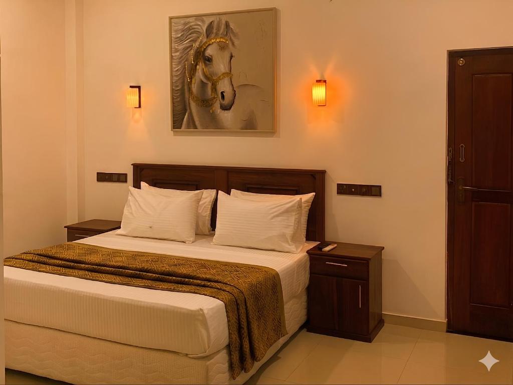 a bedroom with a bed with a horse picture on the wall at H M C Leisure Villa Devinuwara in Dondra North