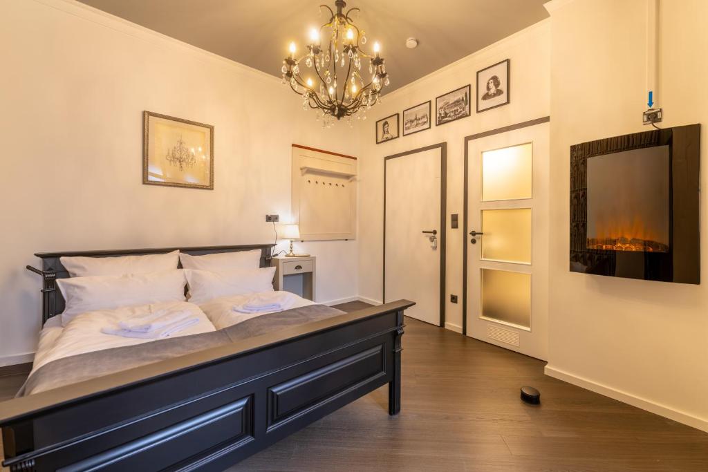 a bedroom with a large bed and a chandelier at Family Apartment History 5 Gäste Air Condition Parken Frei in Munich