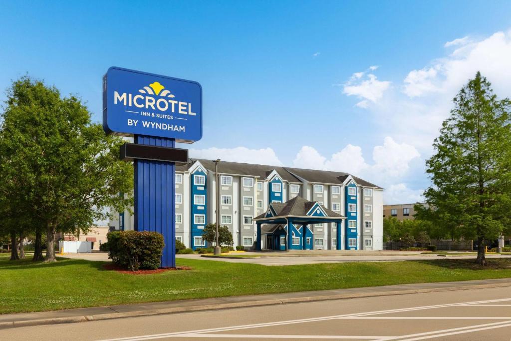 a hotel sign in front of a building at Microtel Inn and Suites Baton Rouge Airport in Baton Rouge