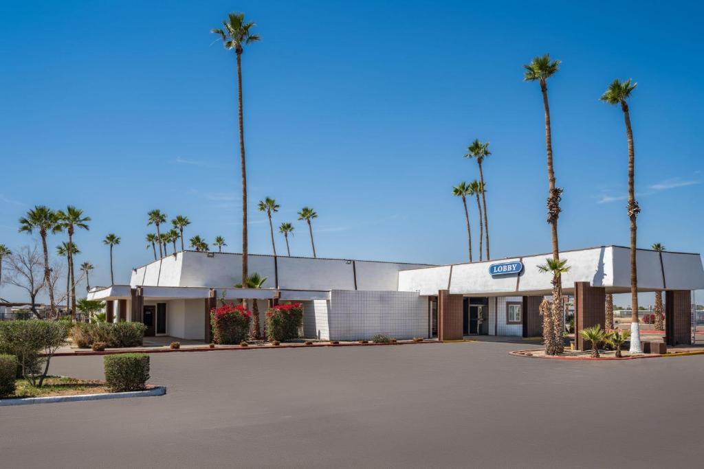 a building with palm trees in front of it at Travelodge by Wyndham Imperial - El Centro in El Centro