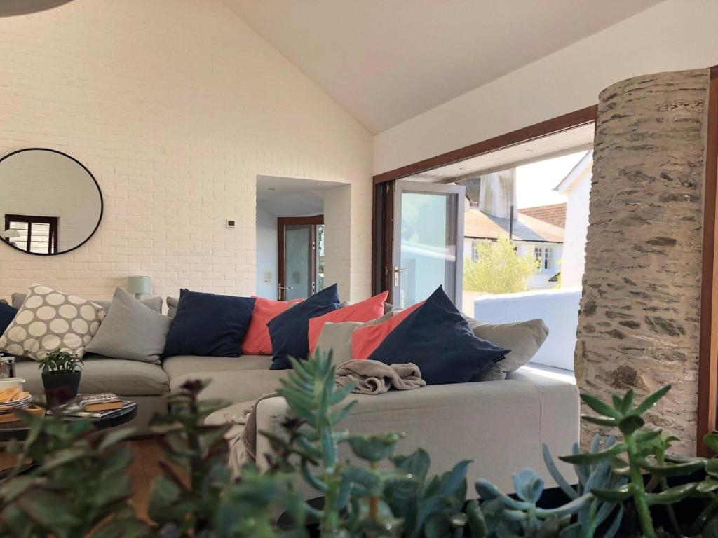 a living room with a couch with colorful pillows at Croyde Barn in Croyde