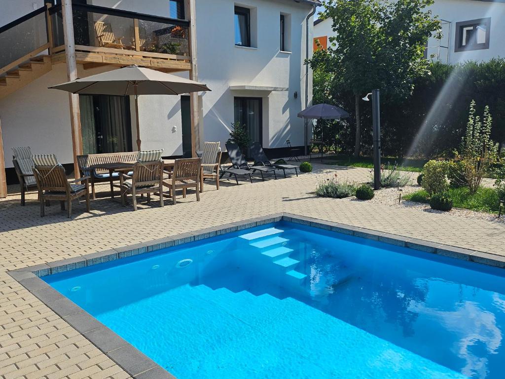 a swimming pool with a table and chairs and an umbrella at Studio apartmen in Budapest