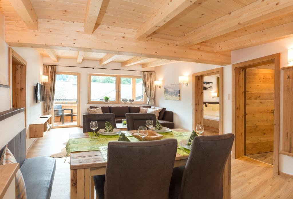 una sala da pranzo e un soggiorno con soffitto in legno. di Talheim Apartments ad Auffach