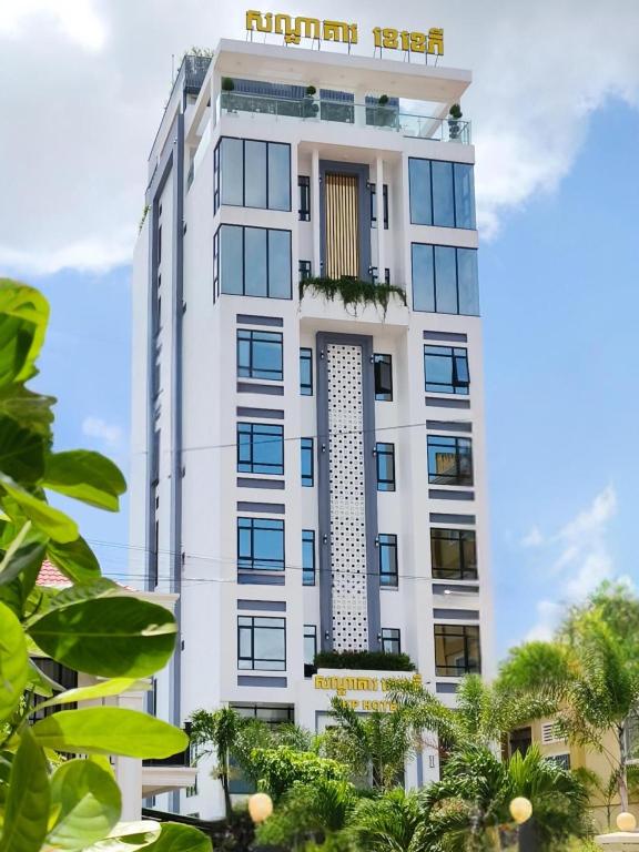 ein weißes Gebäude mit Bäumen davor in der Unterkunft KKP Hotel in Kampot