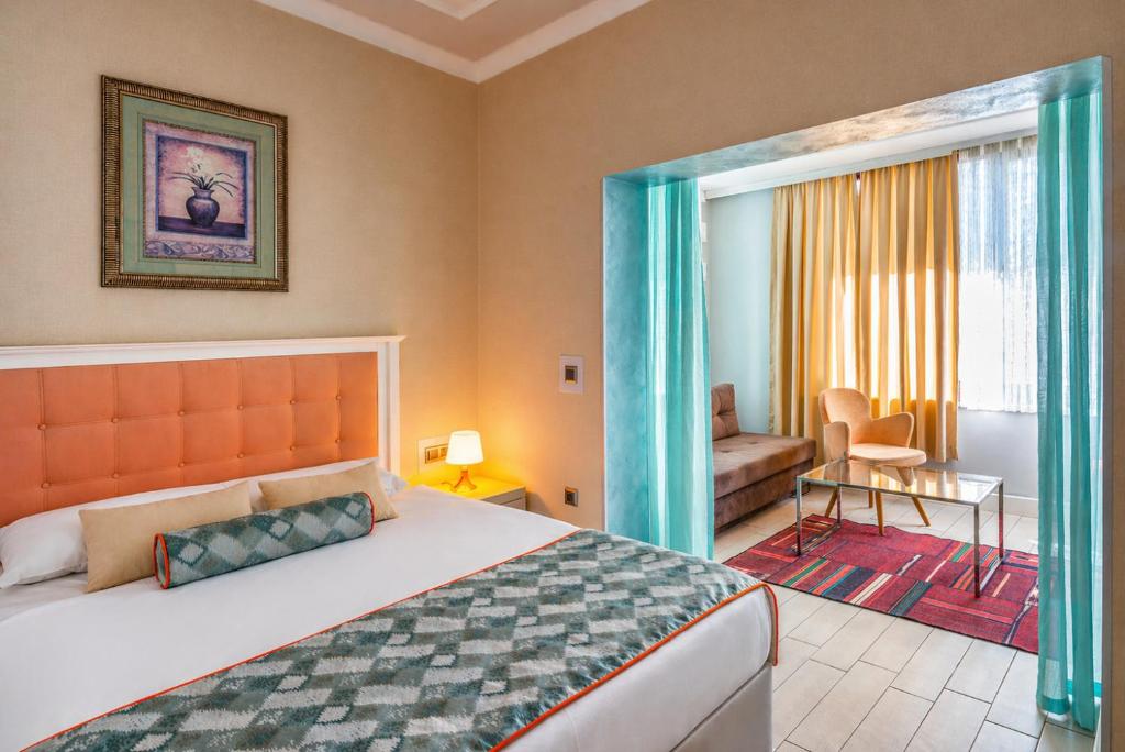 a bedroom with a bed and a living room at Delight Deluxe Aparts in Antalya