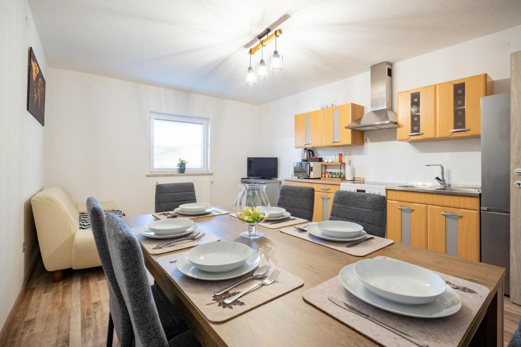 a kitchen and dining room with a wooden table with chairs at Apartment Molnar in Žirovnica
