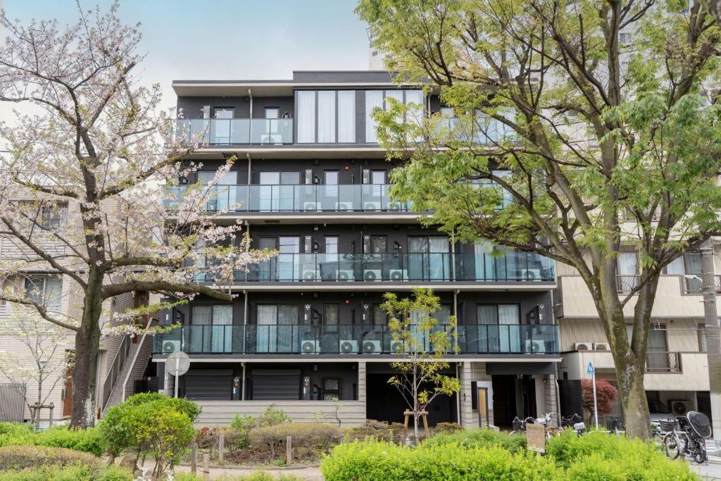 an apartment building with balconies and trees at BON Tokyo Kamata Parkside in Tokyo