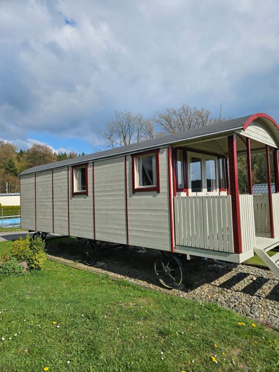 a train car is on display in a yard at Camping La Hêtraie pipowagen in Bullange