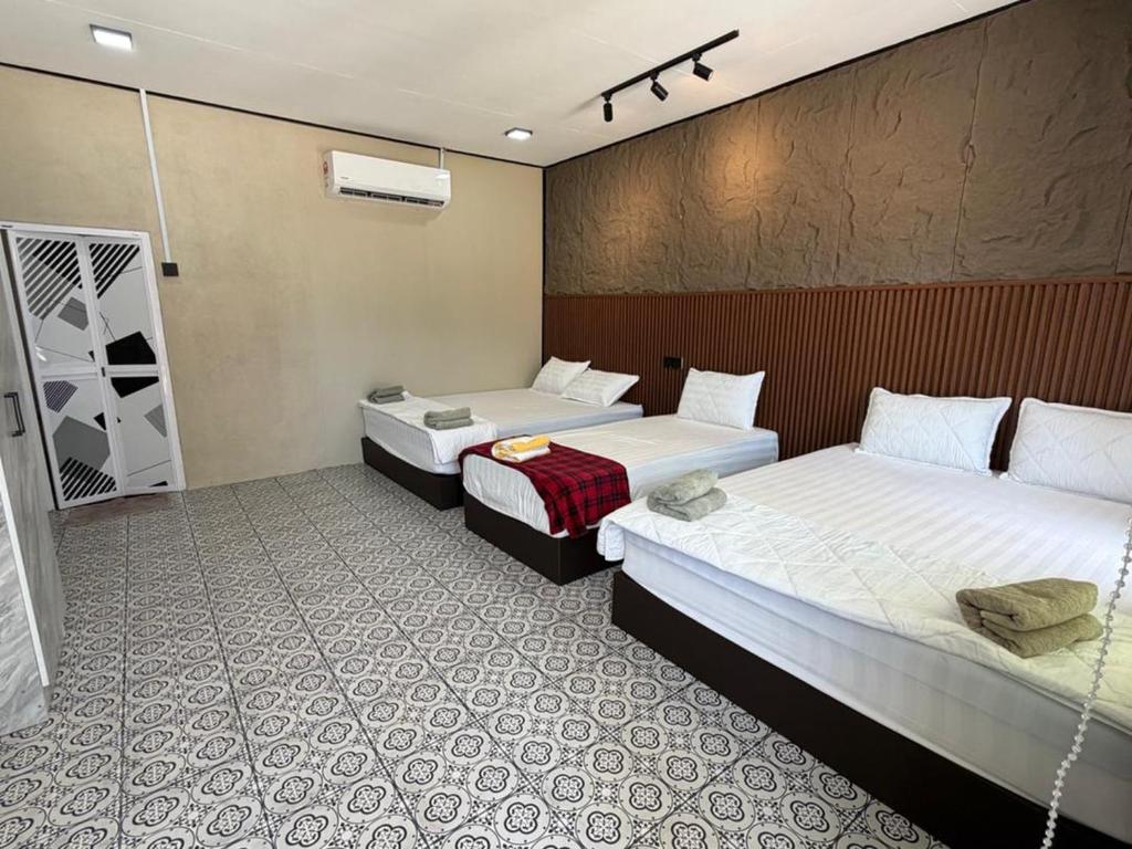 a hotel room with two beds in a room at Khafii House in Kampong Pasir Panjang