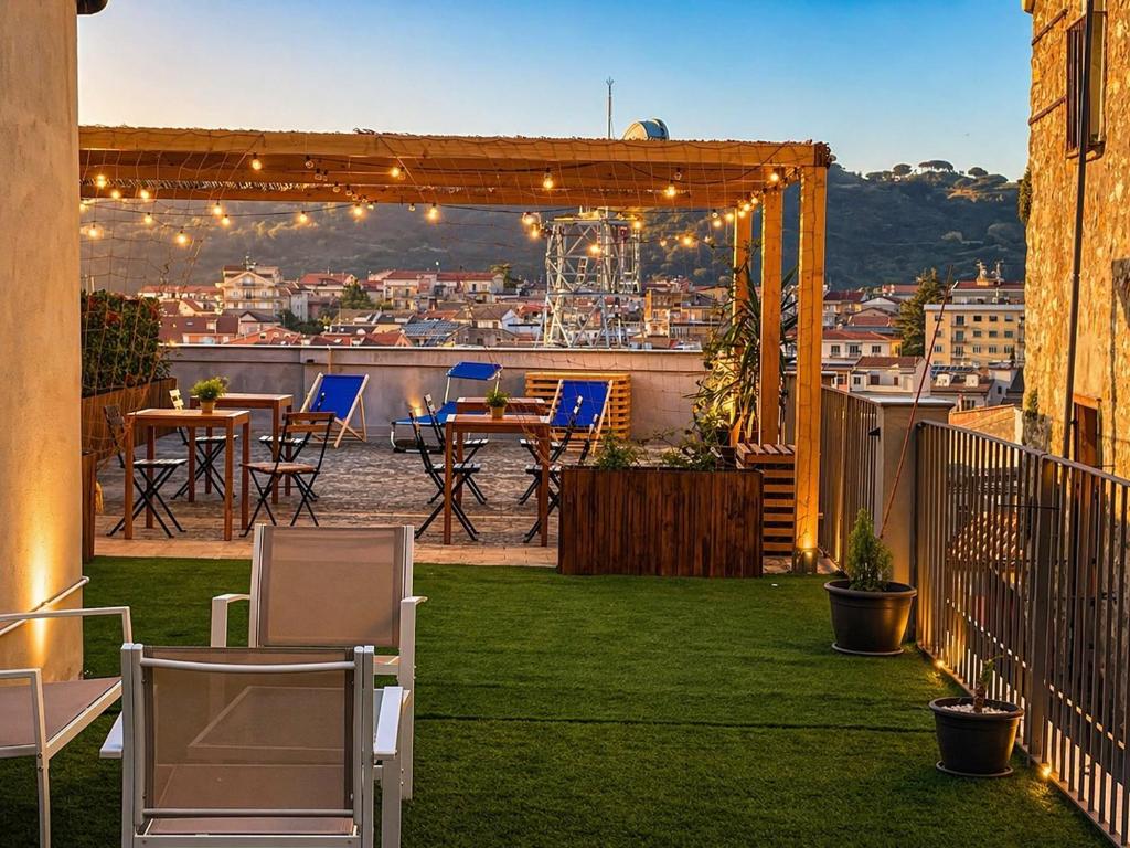 a rooftop patio with a table and chairs on the grass at Camurria Sicilian B&B in Piazza Armerina