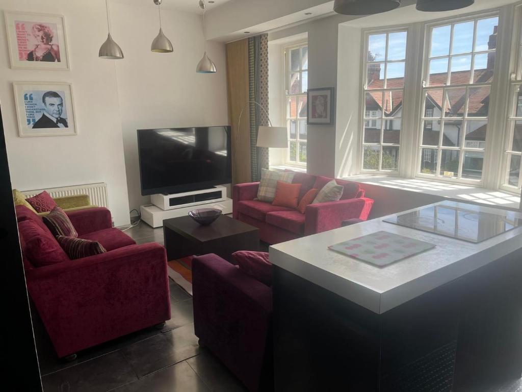 a living room with red chairs and a tv at BAE SUITE 5 min walk to bae systems in Barrow in Furness