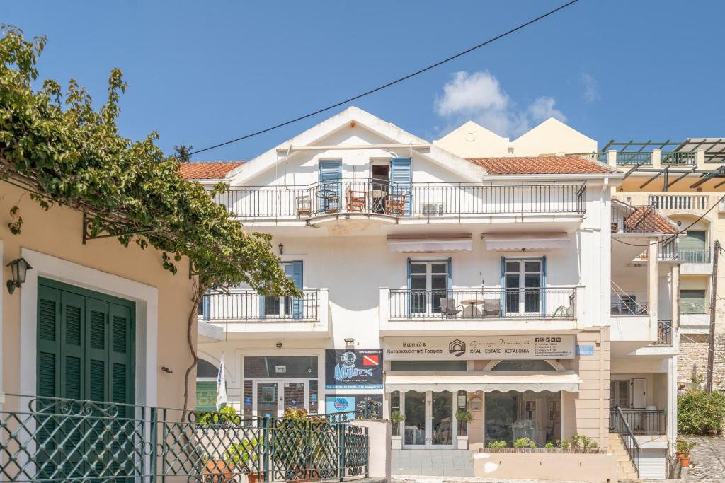 a large white building with a balcony at Pilali Apartments Greece in Agia Effimia