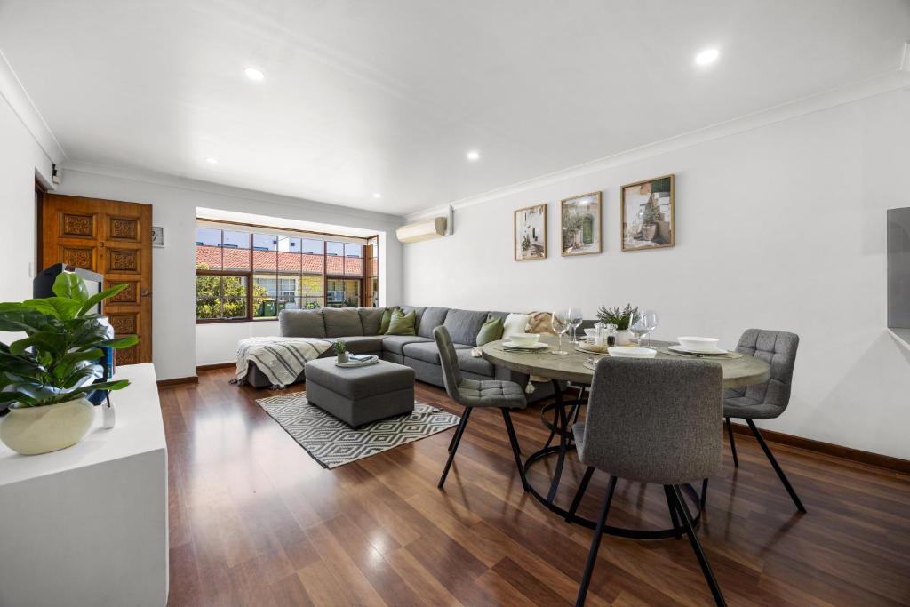 a living room with a table and a couch at Tranquil Suite - Modern Comfort between CBD & Beach in Thebarton