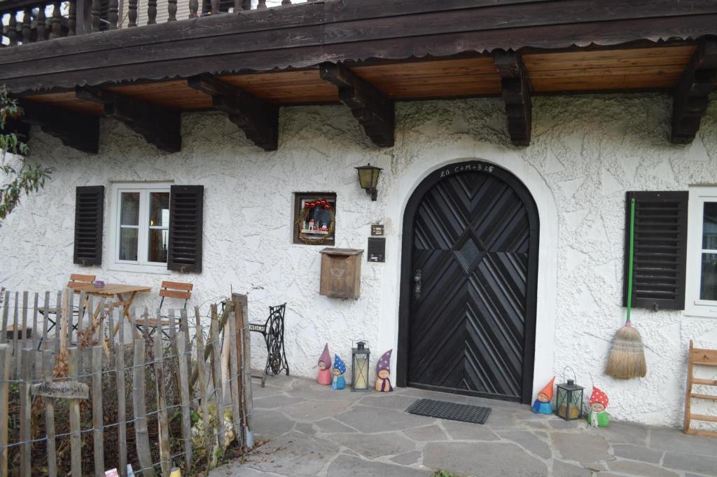 a house with a black door and a wooden roof at Ferienwohnung Perlenreut 1 in Piding
